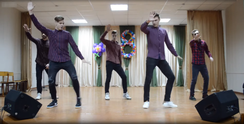 Юноши танцуют на конкурсе 8 марта